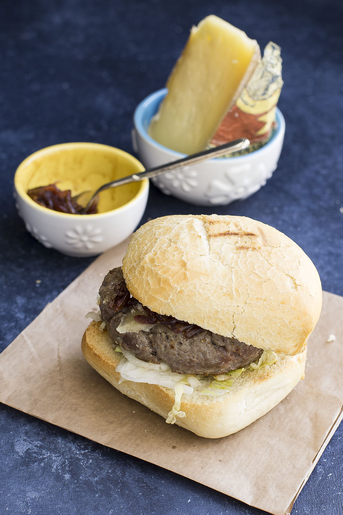 Panino con hamburger di salsiccia di bra, toma e cipolle